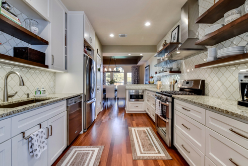 Kitchen tile backsplash extending along the sink and range walls